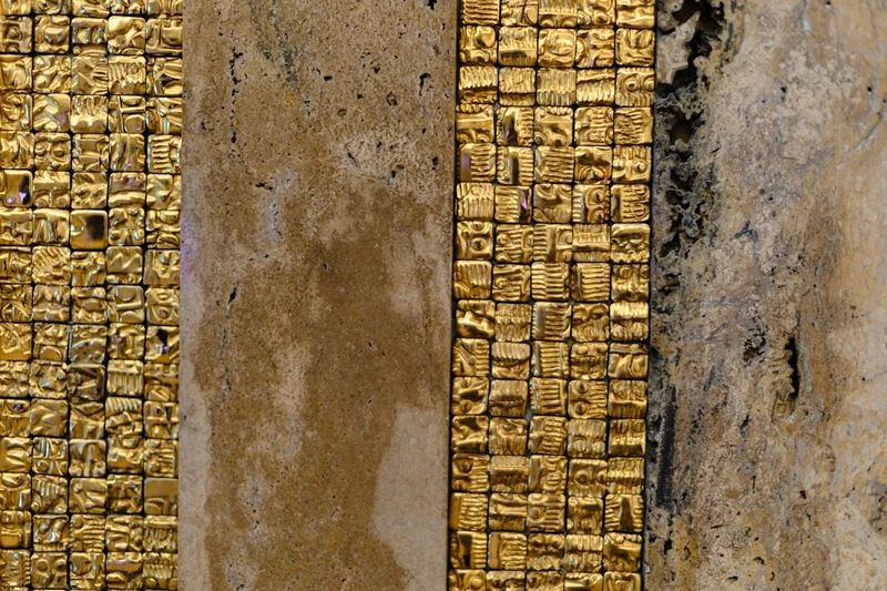 A close up of a brick wall with gold paint